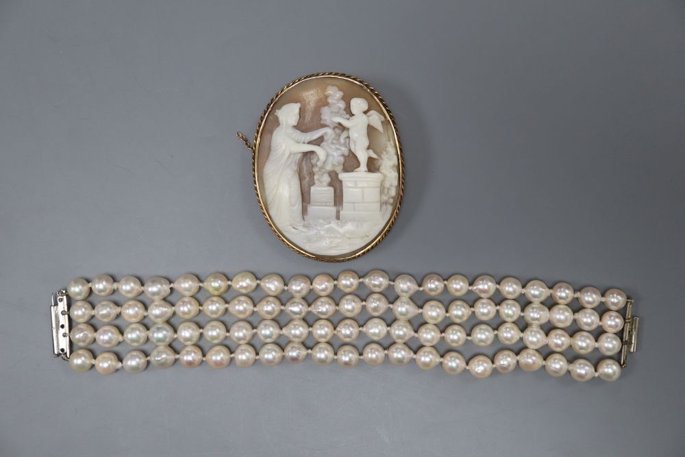 A modern quadruple strand cultured pearl bracelet, 15.8cm and a yellow metal mounted oval cameo shell brooch, 52mm.